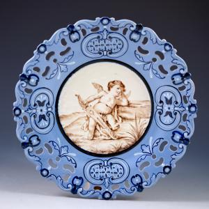 Prato com aba perfurada e decoração representando cupido